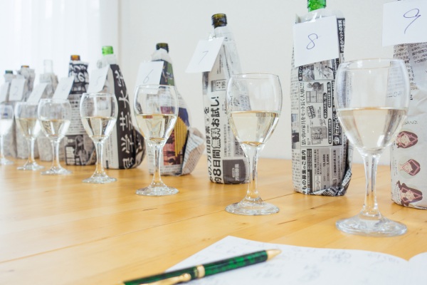 saketaku日本酒完全ブラインドテストで新聞紙で包んだ日本酒のボトルの画像